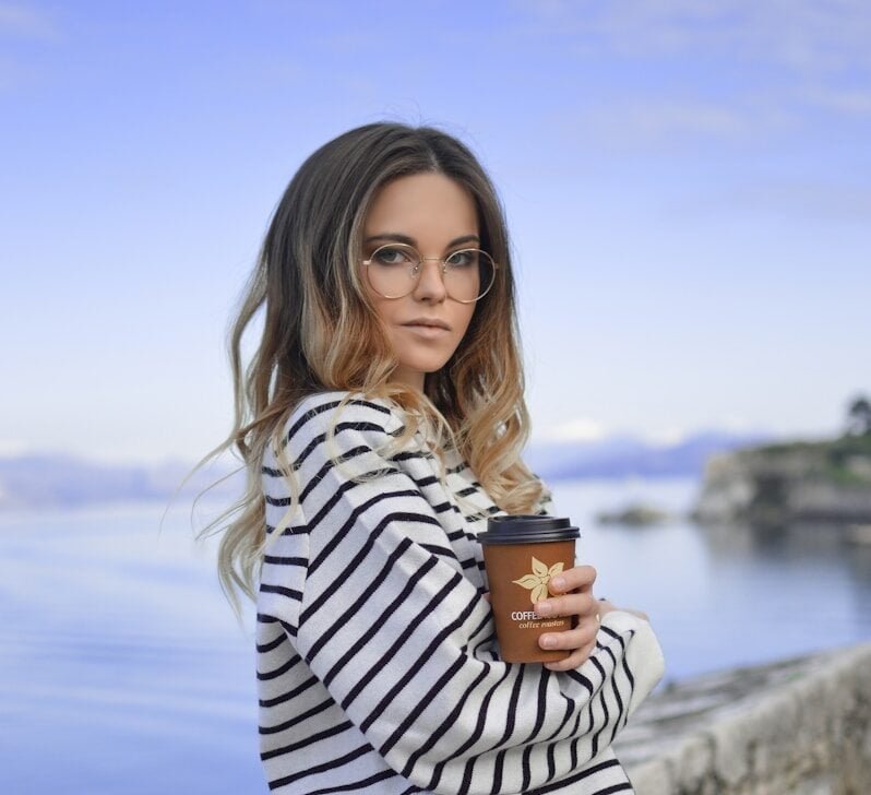 woman in white near calm body of water